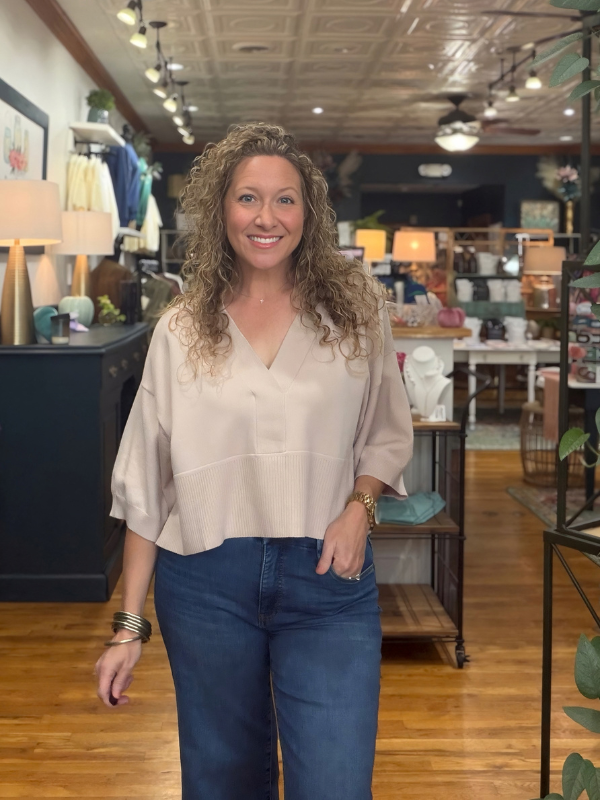woman wearing a beige collared dropped shoulder sweater with jeans