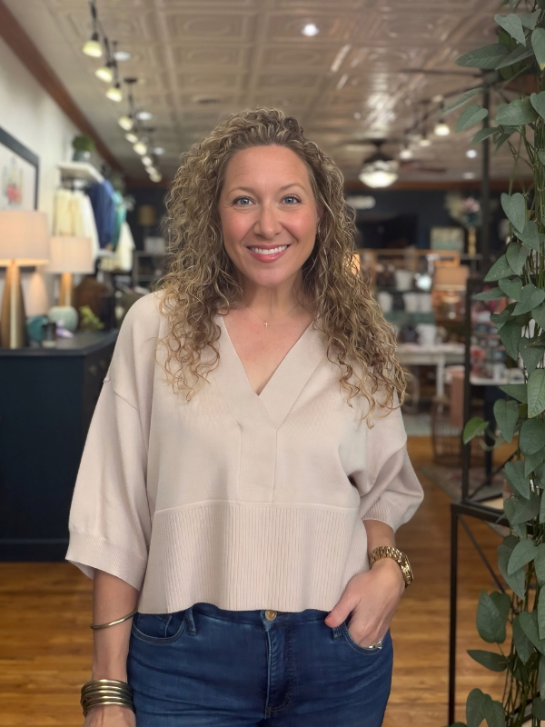 woman wearing a beige collared dropped shoulder sweater with jeans