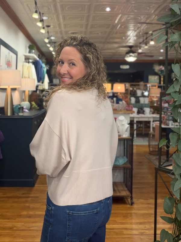 woman wearing a beige collared dropped shoulder sweater with jeans