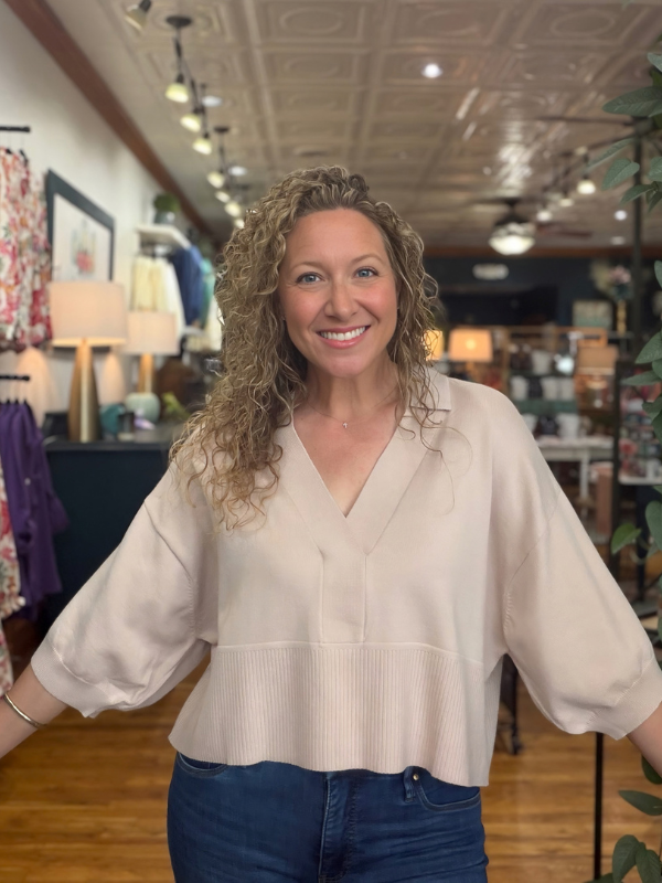woman wearing a beige collared dropped shoulder sweater with jeans