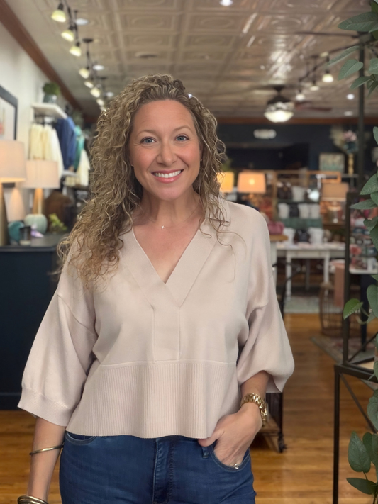 woman wearing a beige collared dropped shoulder sweater with jeans