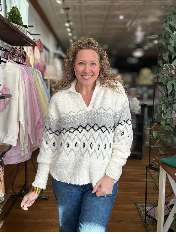 Woman wearing a patterned sweater in a store setting