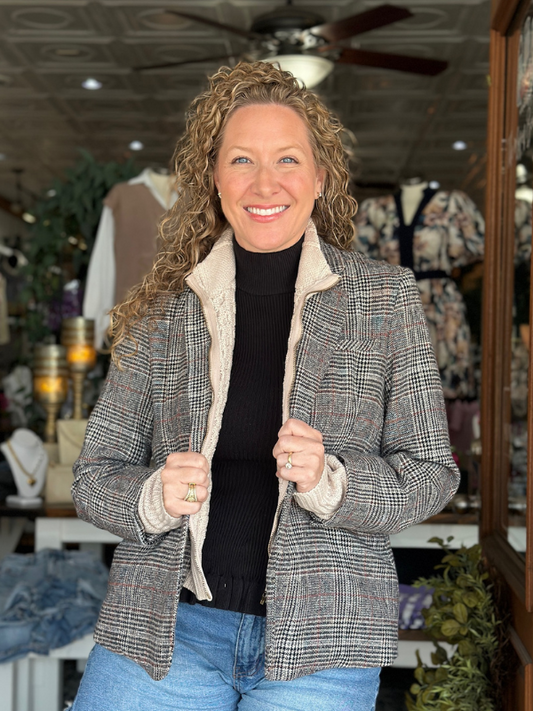 Woman wearing a plaid jacket with a store interior background