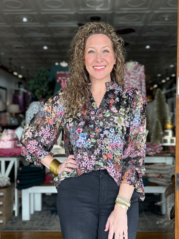 Woman wearing a floral blouse in a store setting
