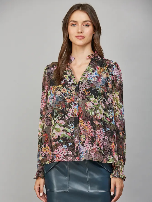 Woman wearing a floral blouse against a gray background