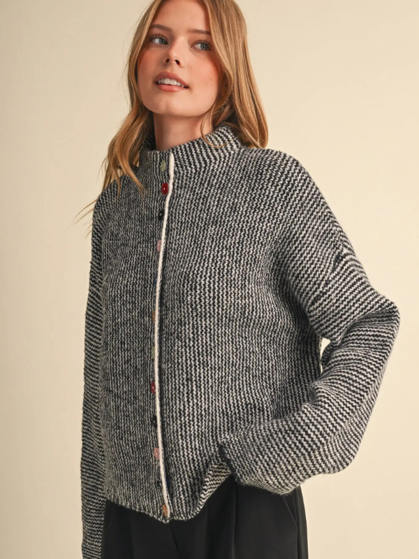 woman wearing a black and ivory sweater with colorful buttons 