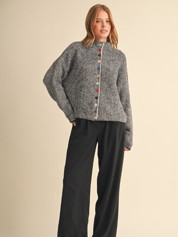 woman wearing a black and ivory sweater with colorful buttons 