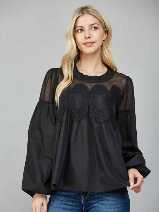 Woman wearing a black blouse with lace details on a gray background