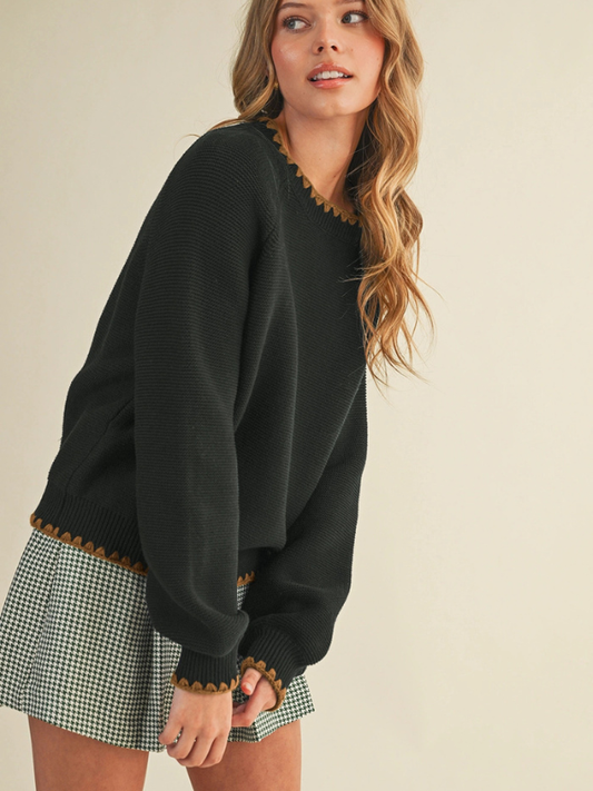 woman wearing a black sweater with mocha stitching 