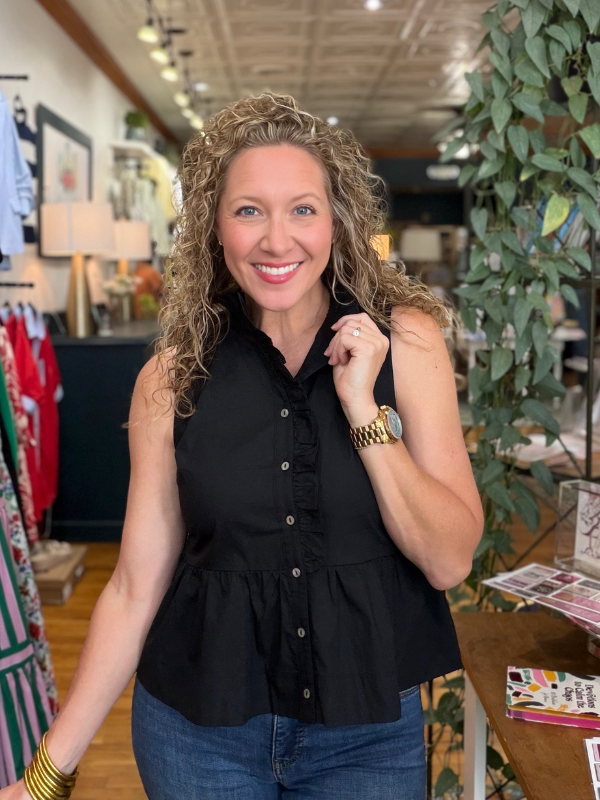 Woman wearing a black sleeveless top in a store setting