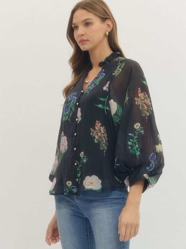 Woman wearing a dark floral blouse with light blue jeans on a white background
