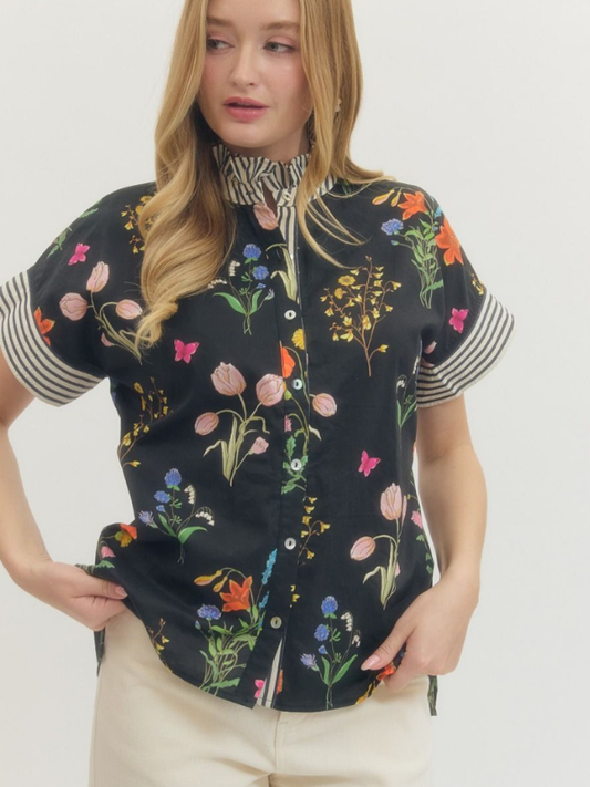 Woman wearing a black floral blouse with a white background