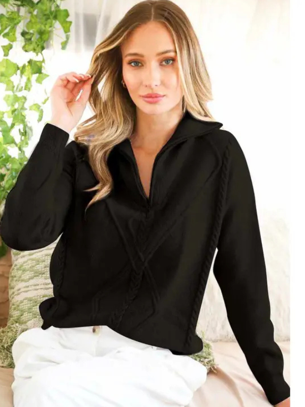 Woman wearing a black long-sleeve top with a blurred background