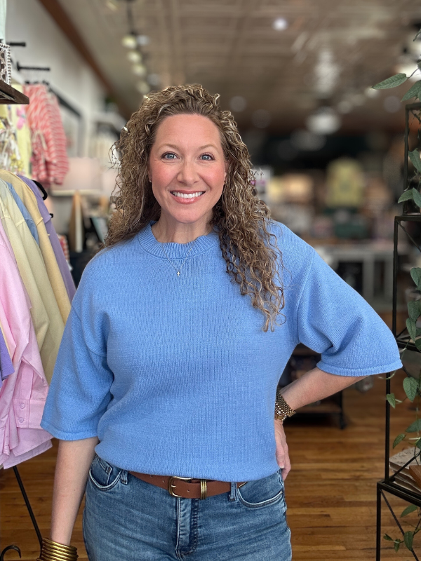 Woman wearing a blue sweater in a store setting