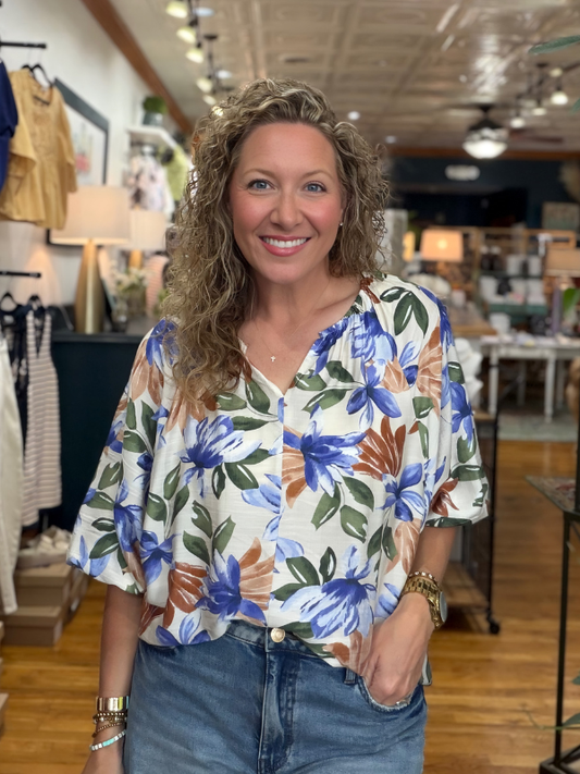 Woman wearing a floral blouse in a store setting
