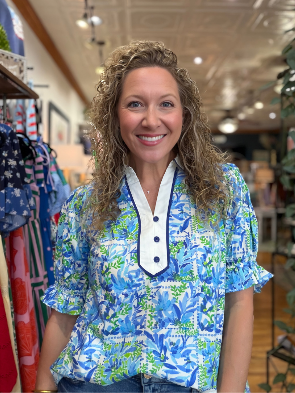 Woman wearing a blue floral blouse in a store setting