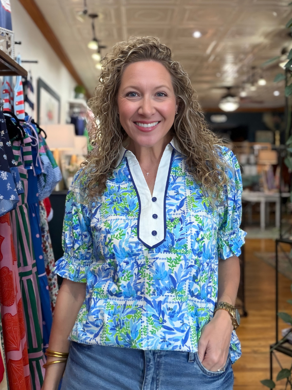 Woman wearing a blue floral blouse in a clothing store