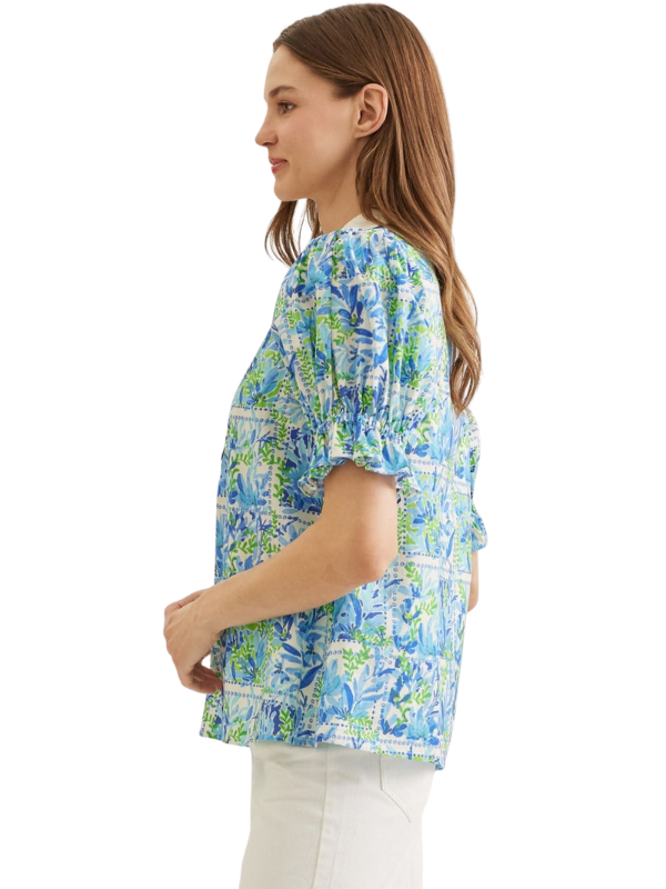 Woman wearing a blue floral patterned blouse on a white background