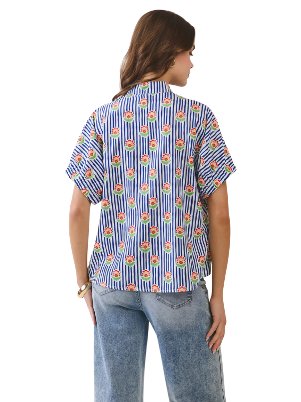 Woman wearing a blue floral patterned shirt on a white background