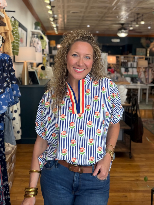 Woman wearing a colorful patterned shirt in a store setting