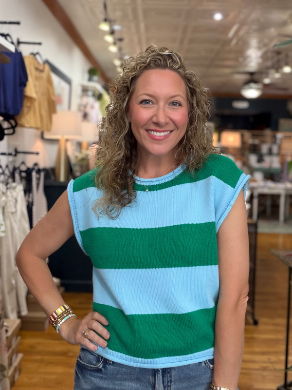 Woman wearing a green and blue striped shirt in a store setting