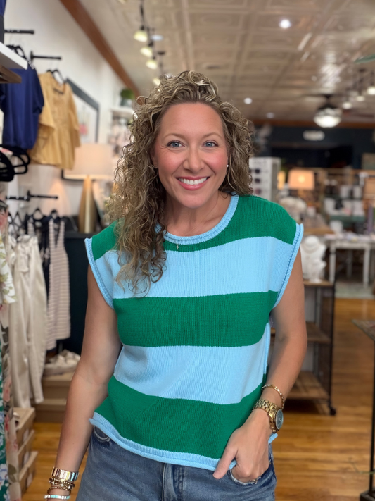 Woman wearing a green and blue striped shirt in a store setting