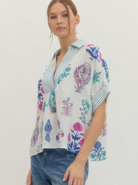 Woman wearing a colorful floral blouse with a plain background