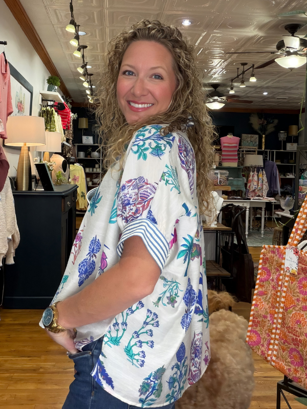 Woman wearing a colorful floral blouse in a store setting