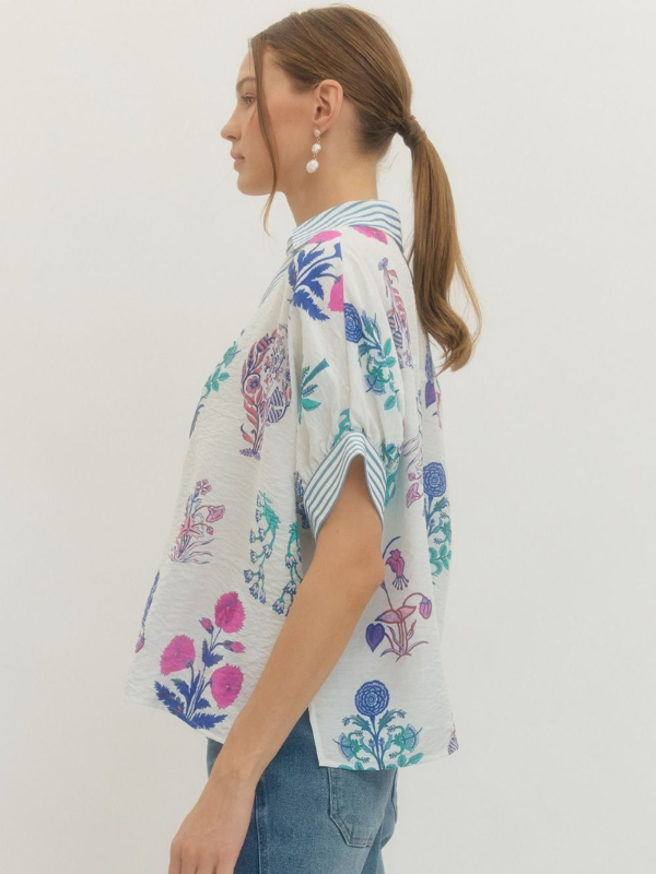 Woman wearing a colorful floral blouse against a white background