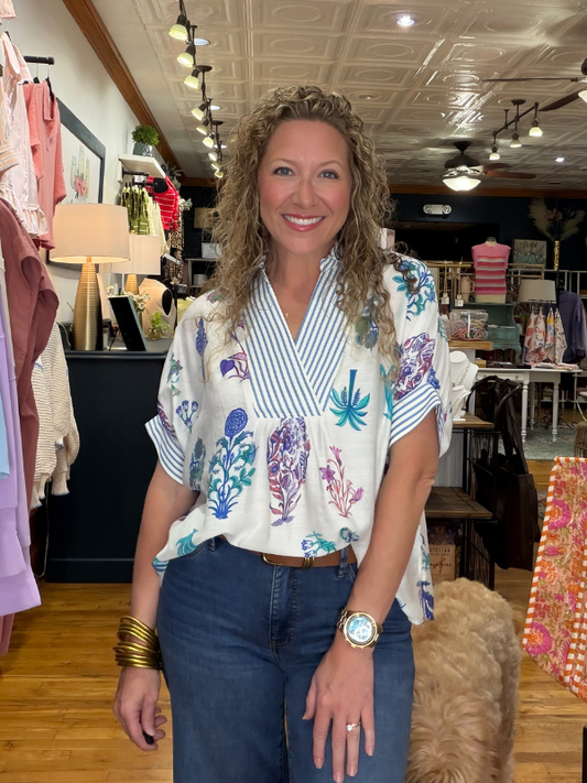 Woman standing in a store with clothing and decor in the background