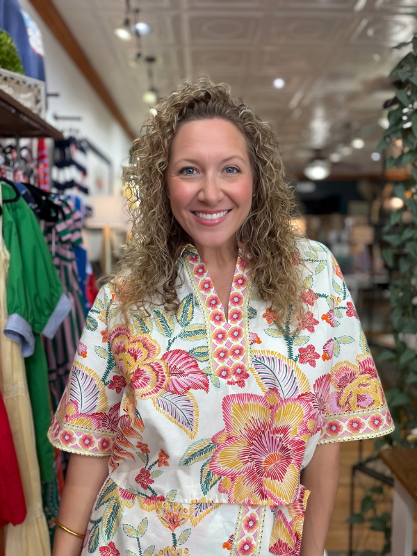Woman wearing a floral dress in a store setting