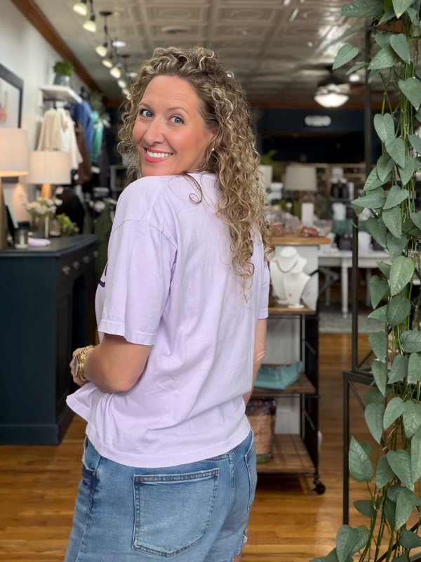 woman wearing a light purple boxy tee that says Mason in dark purple ink 