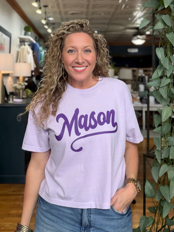 woman wearing a light purple boxy tee that says Mason in dark purple ink 