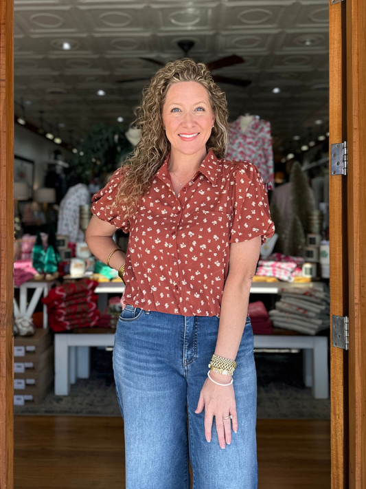 Woman standing in a store with shelves and products in the background