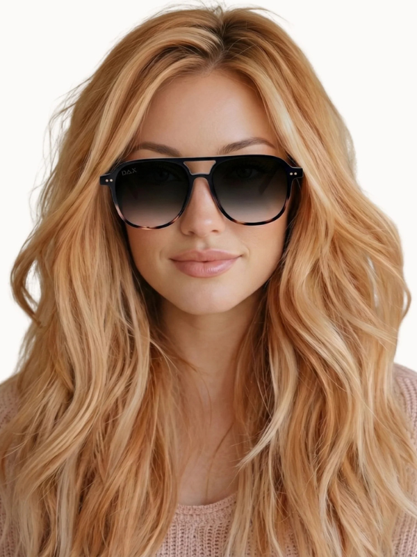 Woman wearing black sunglasses with long blonde hair on a white background