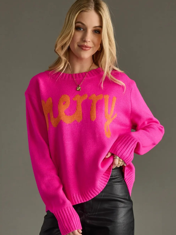 Woman wearing a bright pink sweater with orange text on a gray background