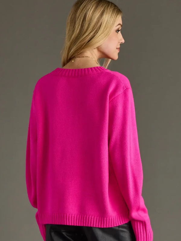 Person wearing a bright pink sweater against a gray background