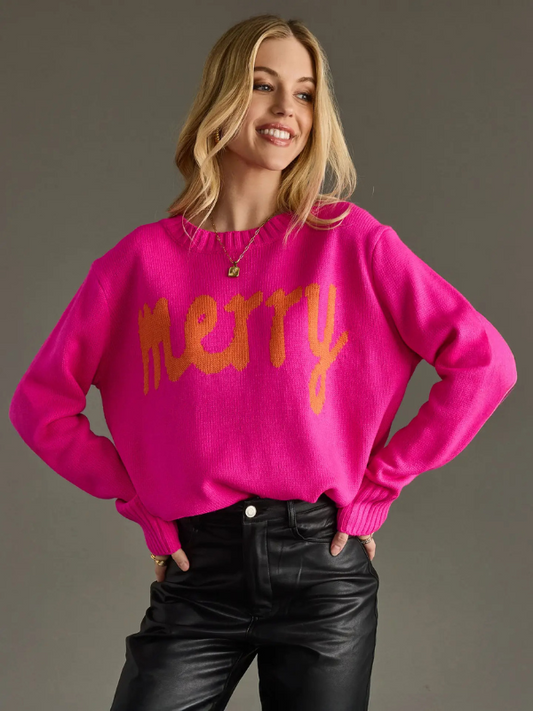 Woman wearing a bright pink sweater with orange text against a gray background