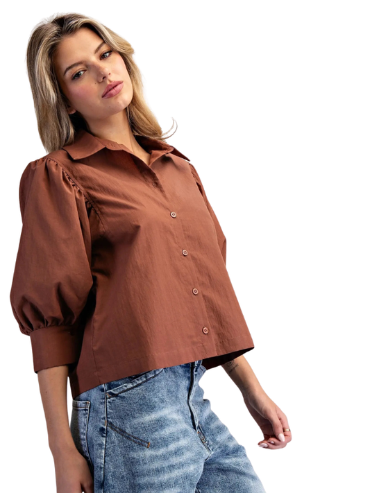 woman wearing bronze puff sleeve top with jeans