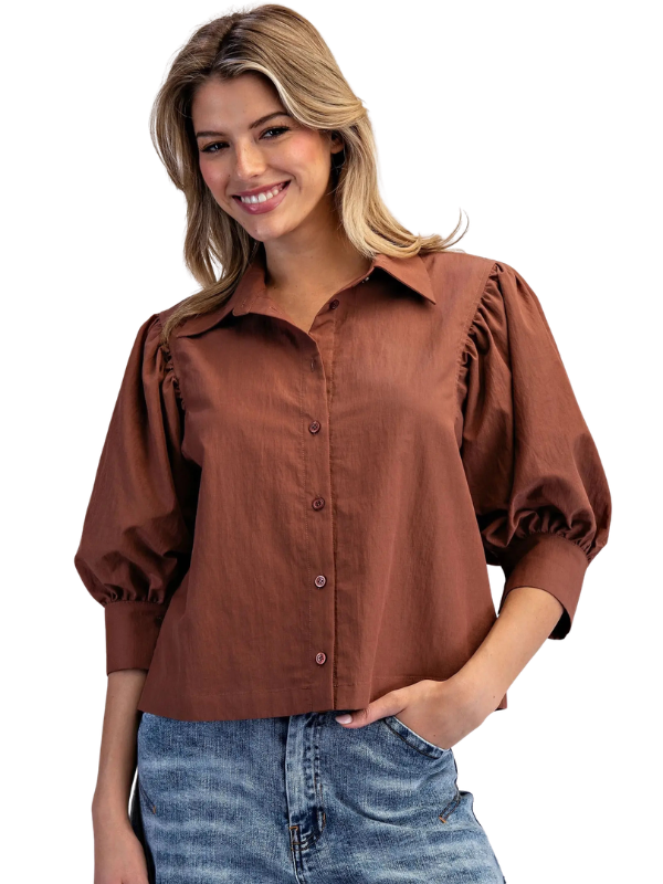 woman wearing bronze puff sleeve top with jeans