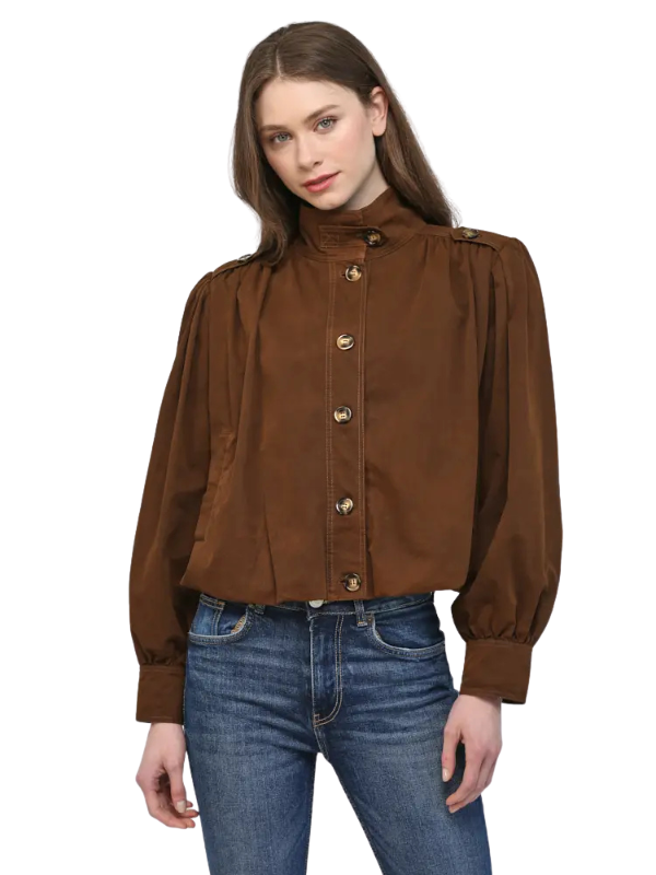 A woman modeling a brown long-sleeve button-up jacket with a high mock neck and gold-tone buttons, paired with blue jeans, against a plain white background.