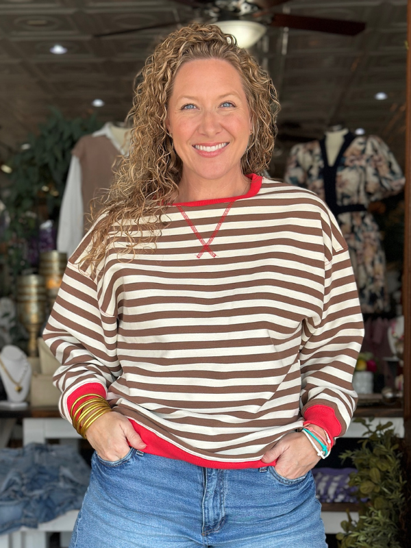 Woman wearing a striped sweater with a blurred indoor background