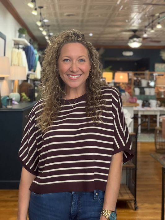 woman wearing a brown and cream dolman sleeve top and jeans