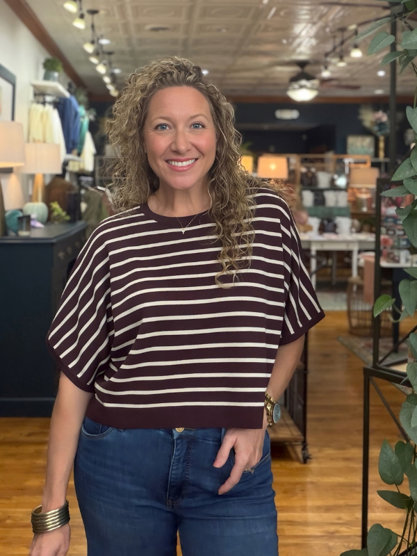 woman wearing a brown and cream dolman sleeve top and jeans