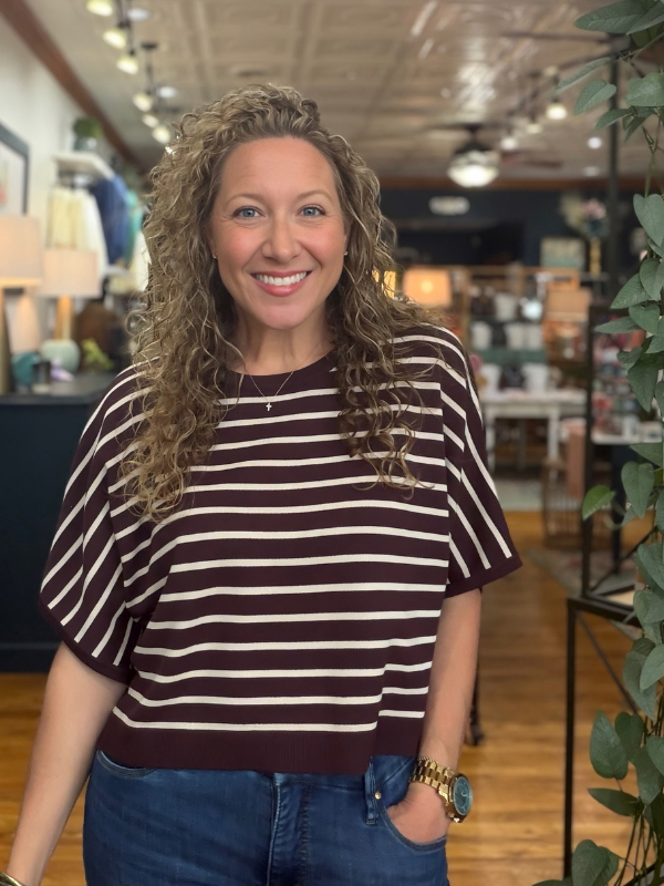 woman wearing a brown and cream dolman sleeve top and jeans