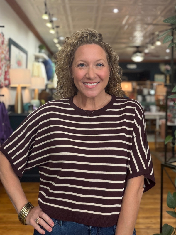 woman wearing a brown and cream dolman sleeve top and jeans