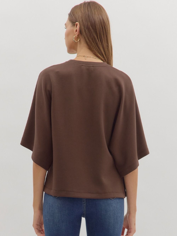 Woman wearing brown elbow sleeve top and jeans 