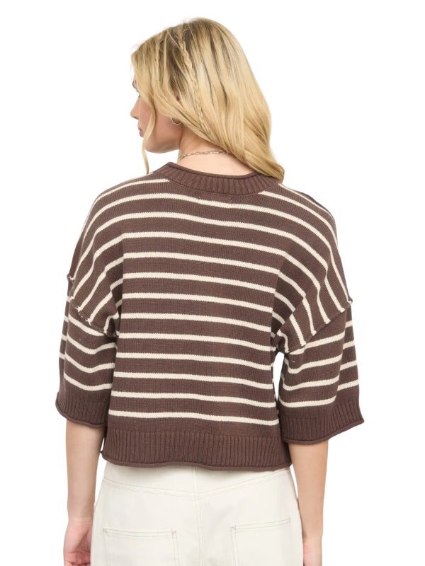 A woman shown from the back wearing a cropped knit sweater with horizontal brown and cream stripes, paired with off-white pants, against a plain white background.