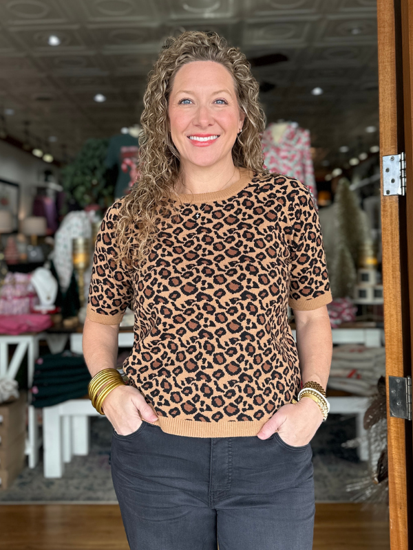 Woman wearing a leopard print sweater in a store setting