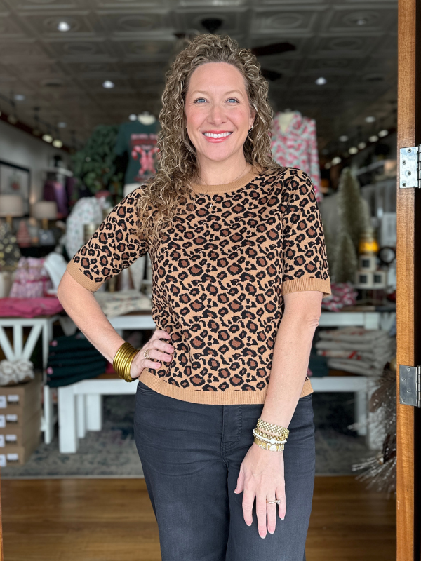 Woman wearing a leopard print top in a store setting
